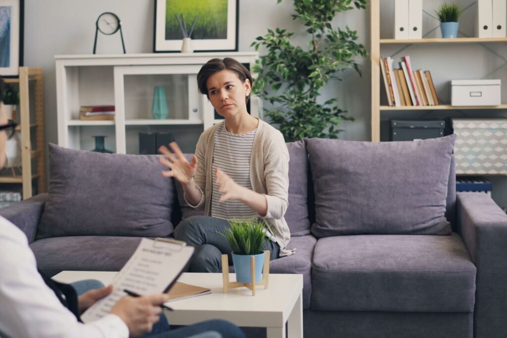 Woman talking with her therapist during a counseling session in a bright, plant-filled office